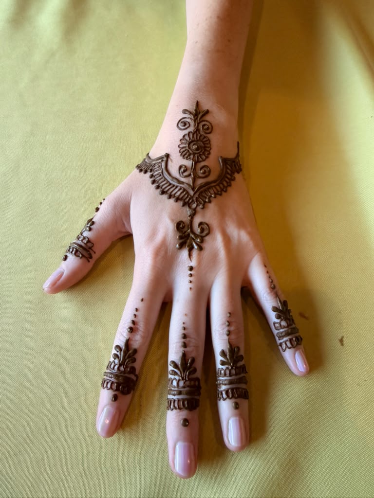 Detailed henna design beside flowers